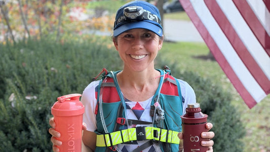 Jodie after a run in her running vest, holding her shaker bottle and IM8 bottle